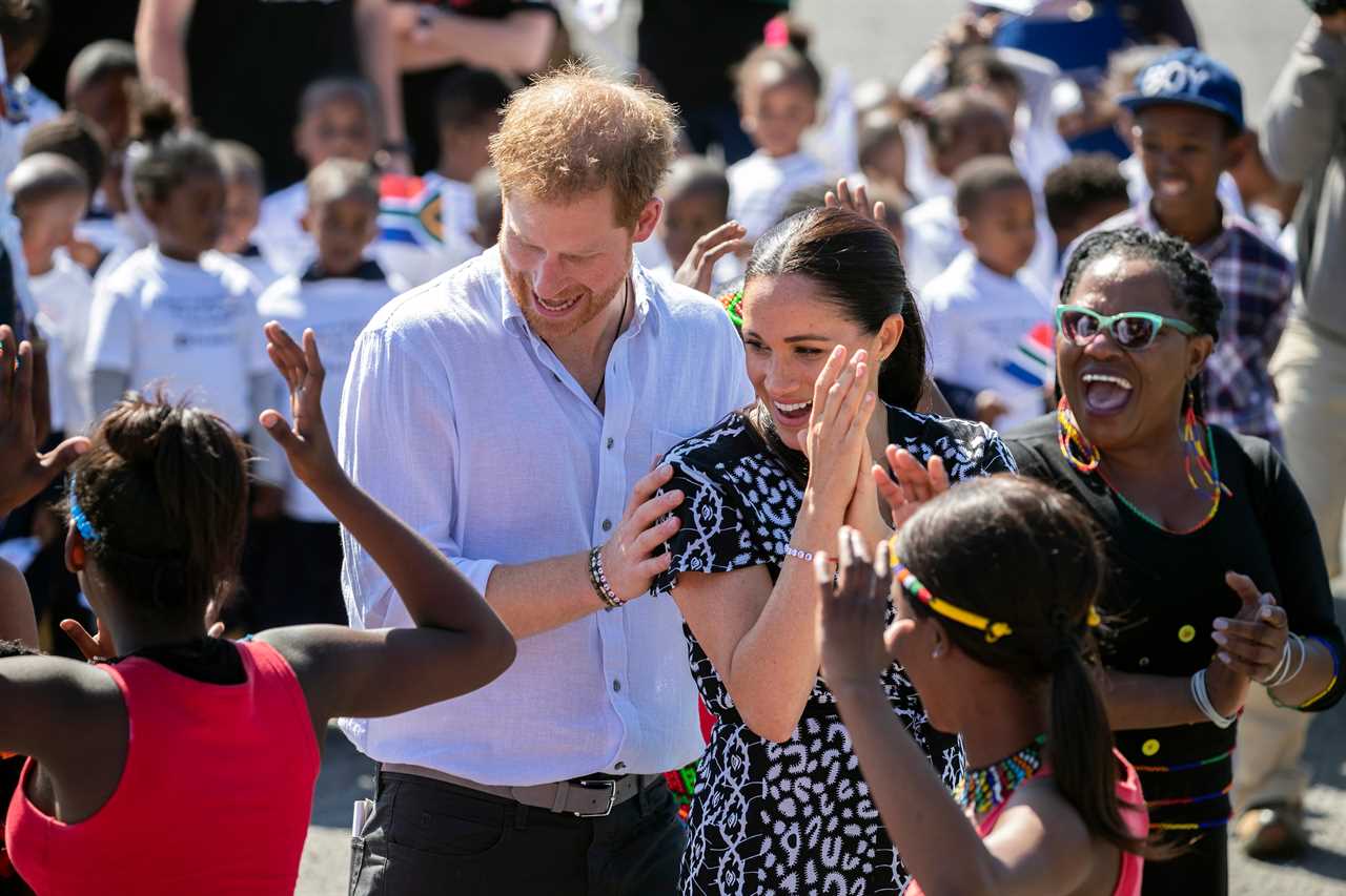 The Queen wanted to give everyone a 'breather' after the tumultuous few months, it was claimed - with Meghan Markle and Prince Harry pictured dancing here during their Royal Tour of Africa