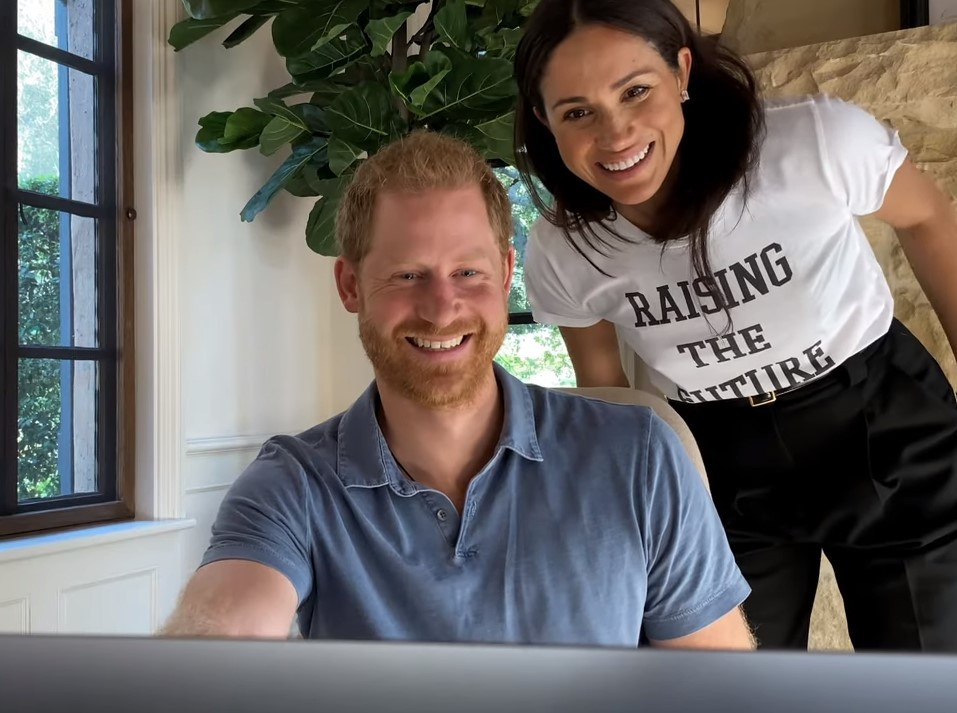 Prince Harry and Meghan Markle can be seen smiling in the new clip released today