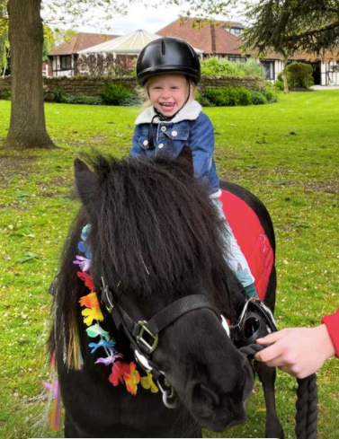 Rex looked so happy riding the pony in his garden