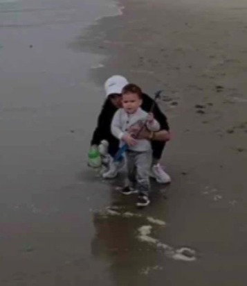 Archie's face can finally be seen in a clip as he plays on the beach with his mum Meghan