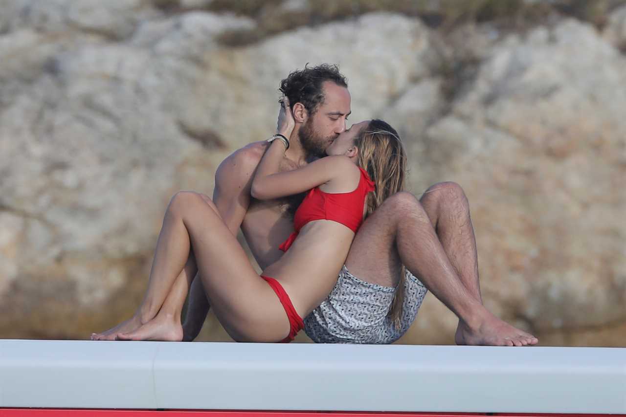 The couple share a passionate kiss while on holidays