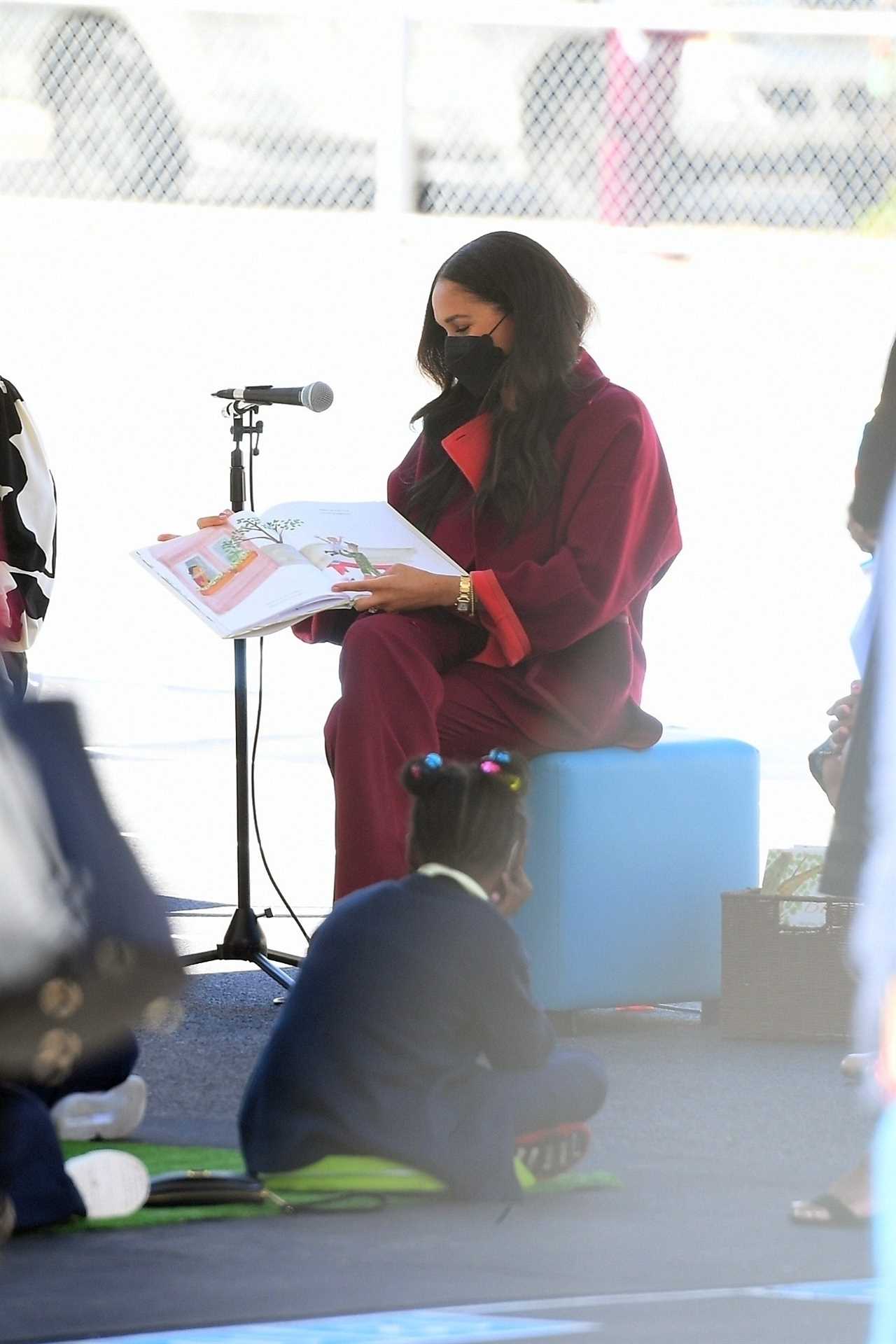 Schoolkids watch on as Meghan reads her book