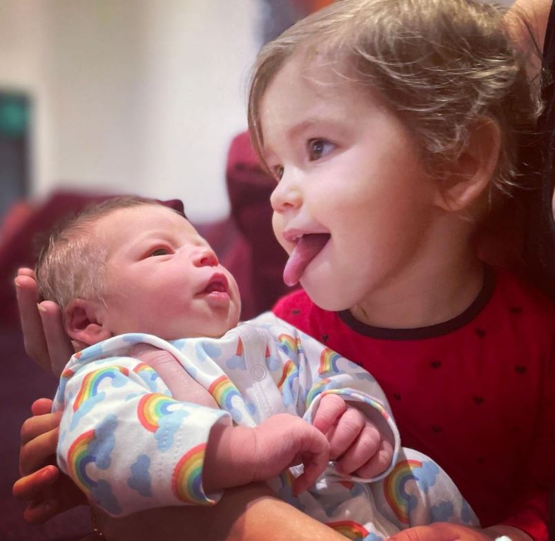 The couple's first child Maven was seen cradling the new arrival