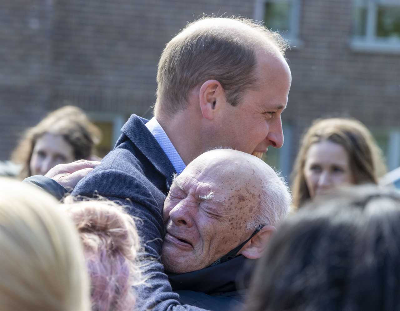 Prince William embraces a pensioner on a walkabout in Glasgow yesterday