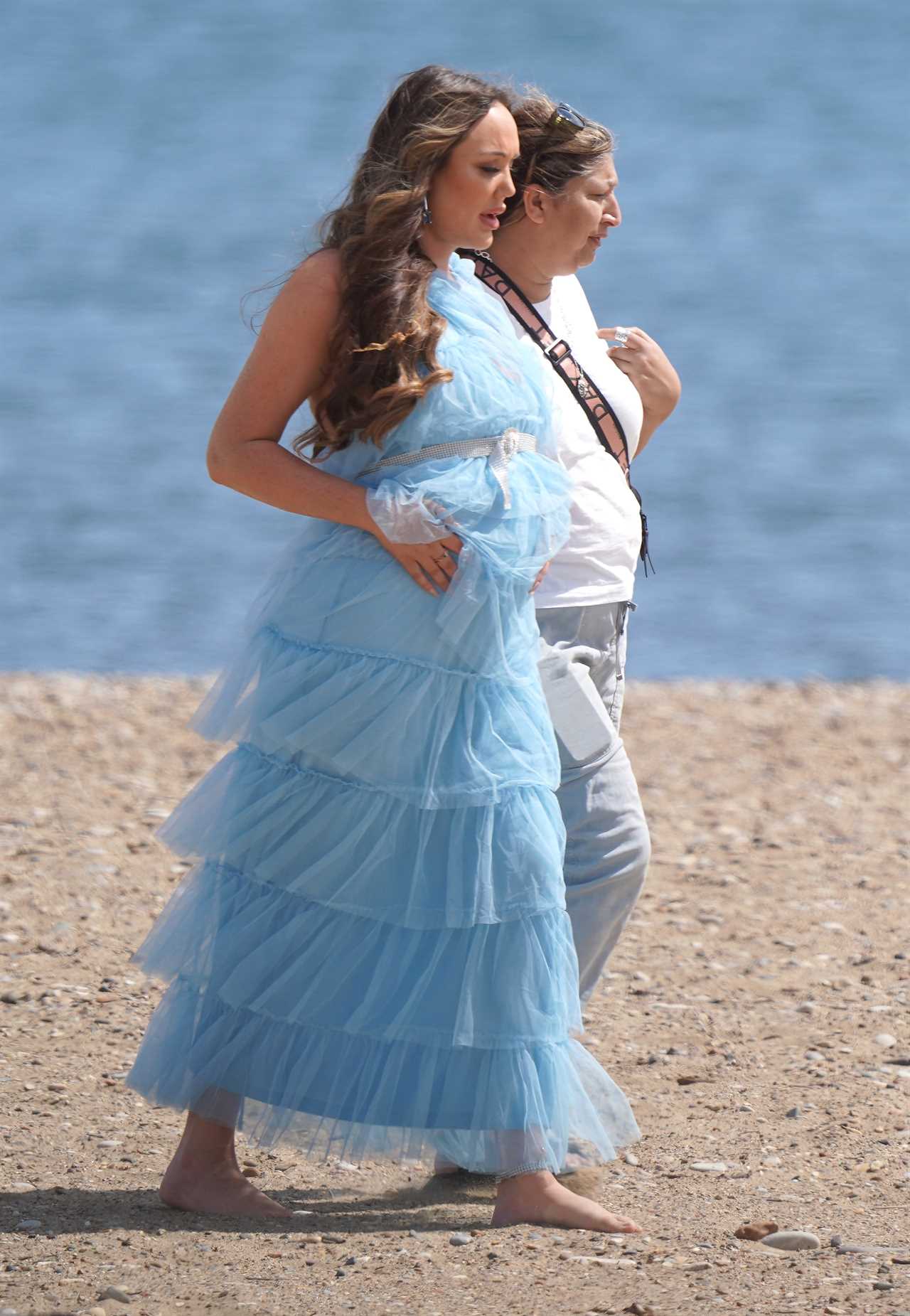 Charlotte Crosby cradles her baby bump in frilly blue dress as she films on the beach in Sunderland