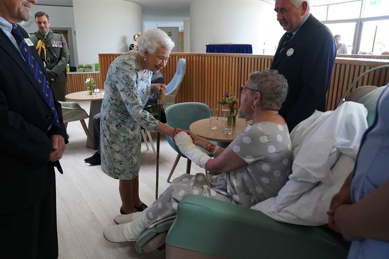 Queen, 96, beams in summer florals as she makes surprise visit to support hospice patients