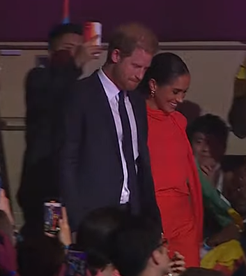 Meghan Markle beams as she takes to stage with Prince Harry and joins Bob Geldof ahead of speech