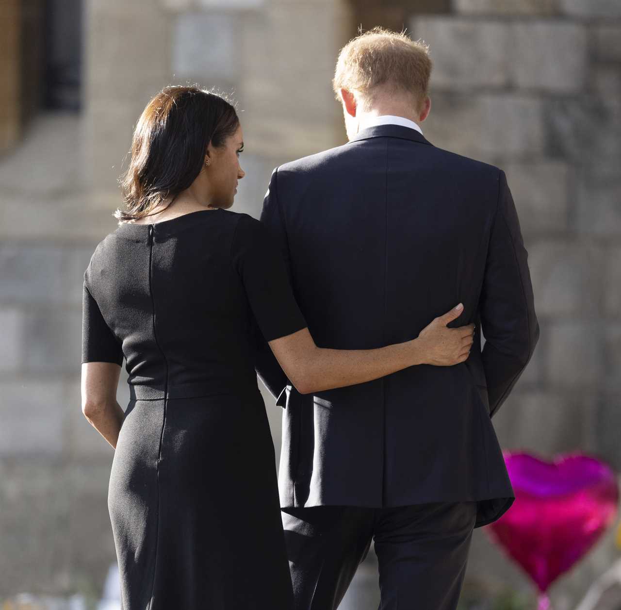 Sweet moment Meghan Markle comforts Prince Harry as he looks at floral tributes for the Queen