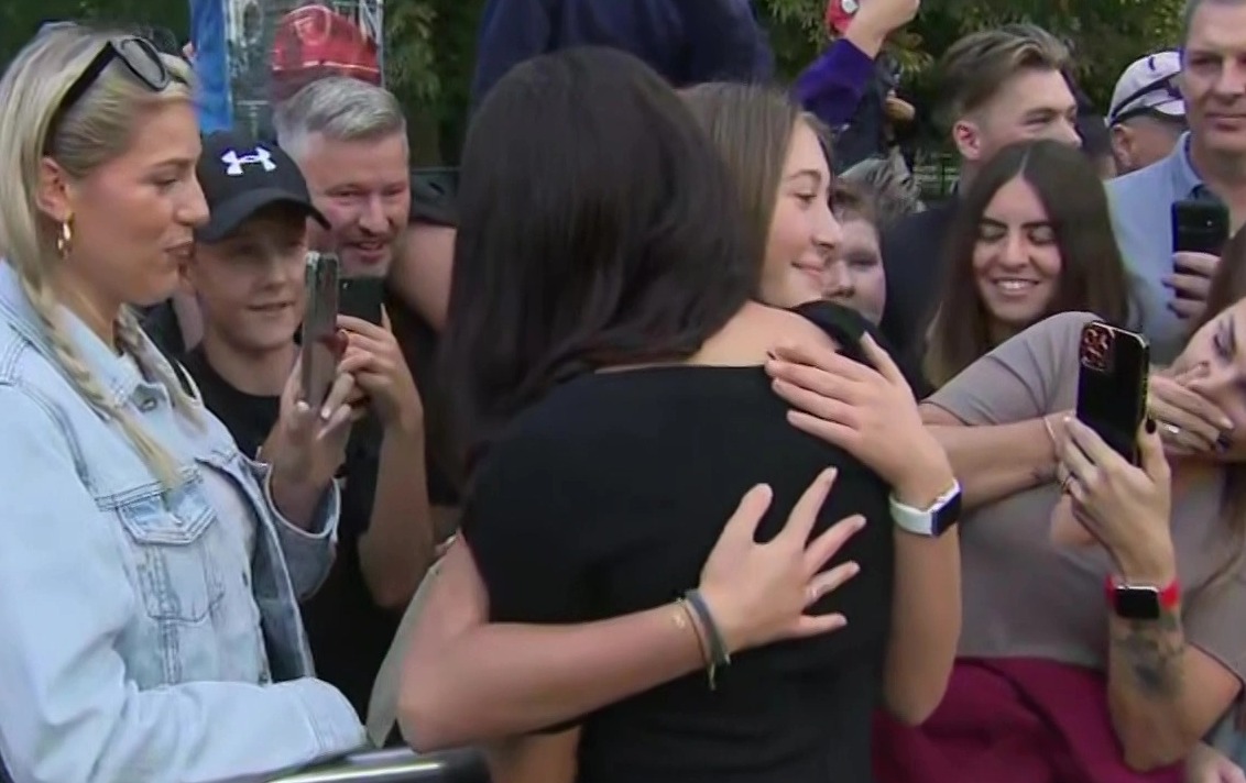 Sweet moment Meghan Markle comforts Prince Harry as he looks at floral tributes for the Queen