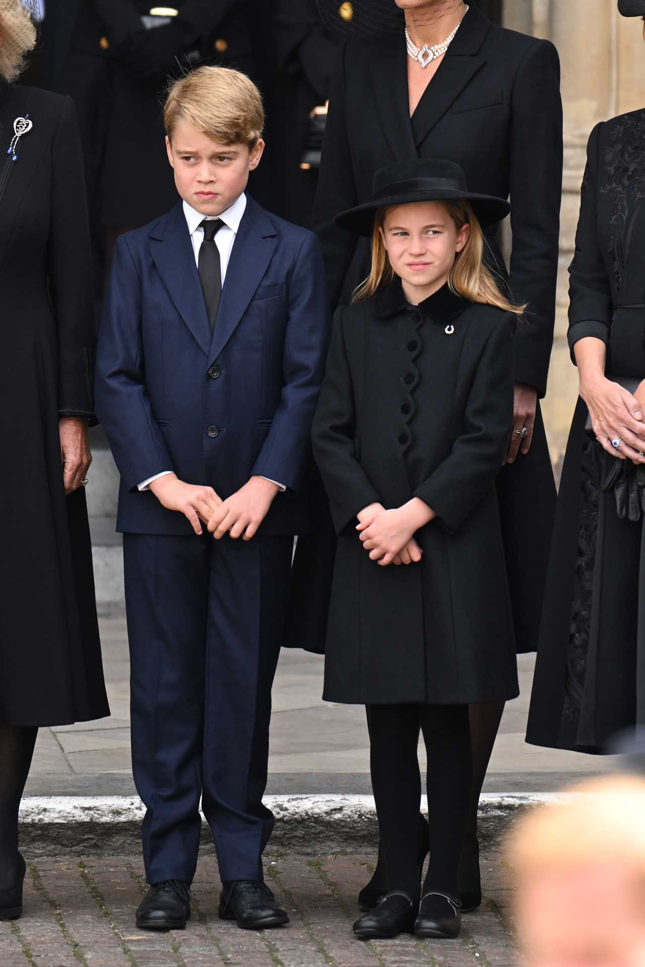 Cheeky Prince George spotted poking out his tongue as he sits next to Charlotte after Queen’s funeral procession