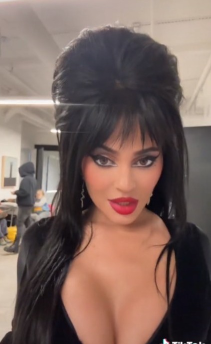Kylie Jenner almost busts out of plunging tight dress as star channels Elvira in raunchiest Halloween video yet