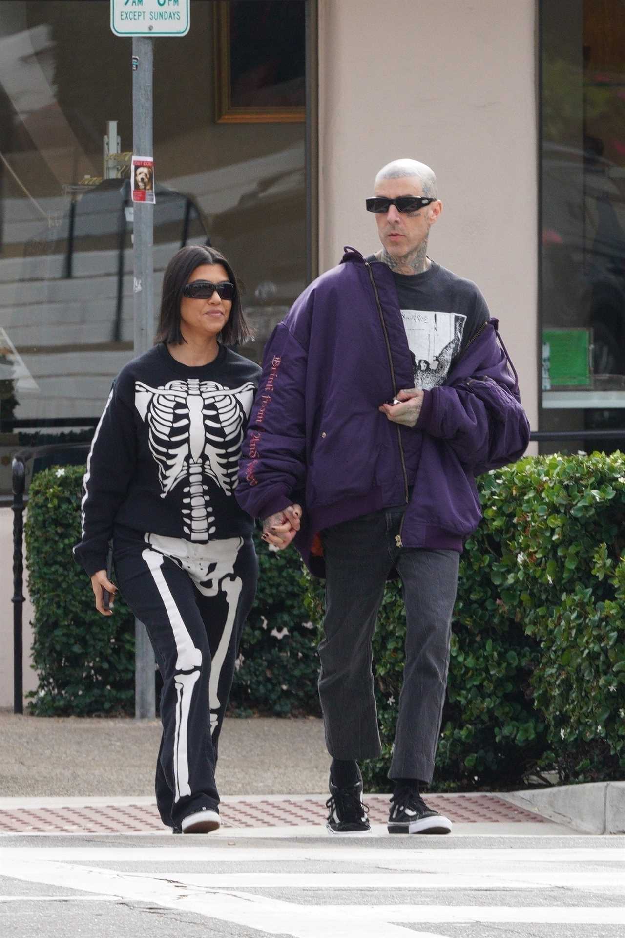Kourtney Kardashian covers her stomach in baggy skeleton onesie after fans think she ‘subtly revealed her pregnancy’