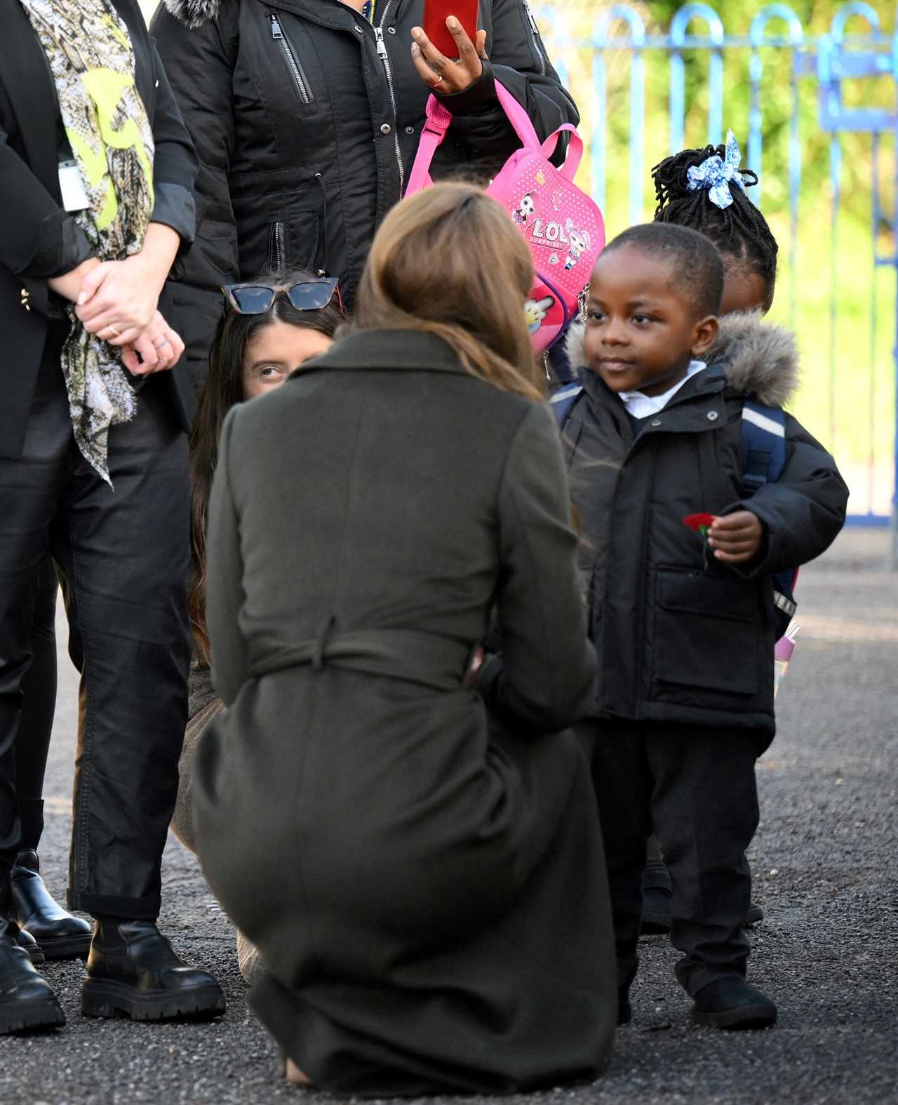 Princess of Wales hands her poppy to a 3-year-old boy on visit to children’s centre in London