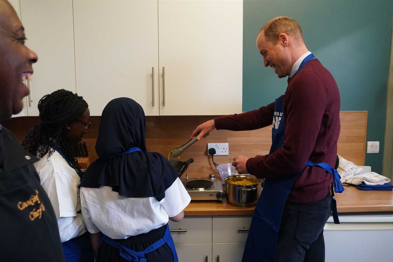 Prince William shrugs off brother Harry’s explosive bio as he focuses on Royal duties & cooks with kids on charity visit