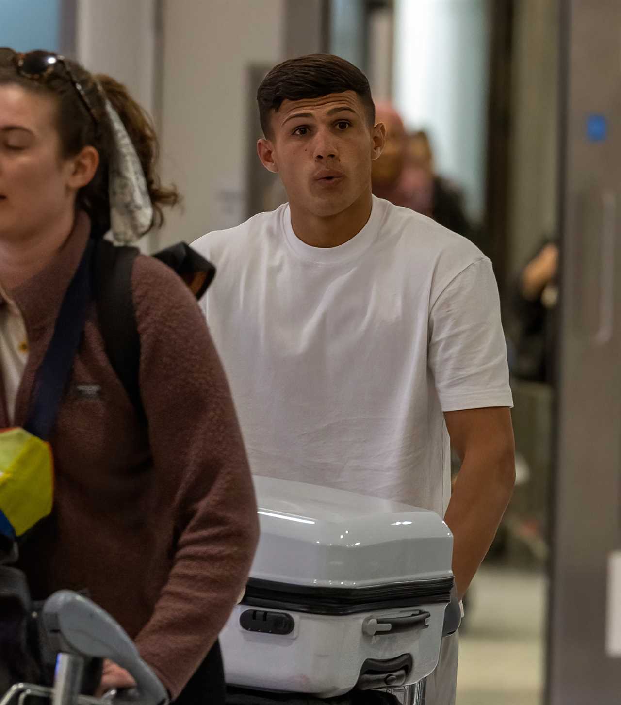 Dumped Love Island star Haris Namani looks downcast as he arrives back in the UK after shock punch video