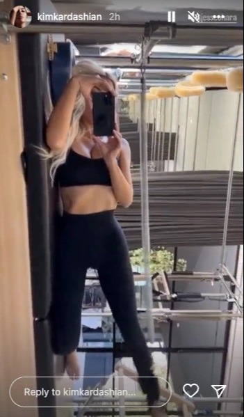 Kardashian fans catch a quick glimpse of Kim showing off her tiny waist in sports bra and tight leggings for a new video