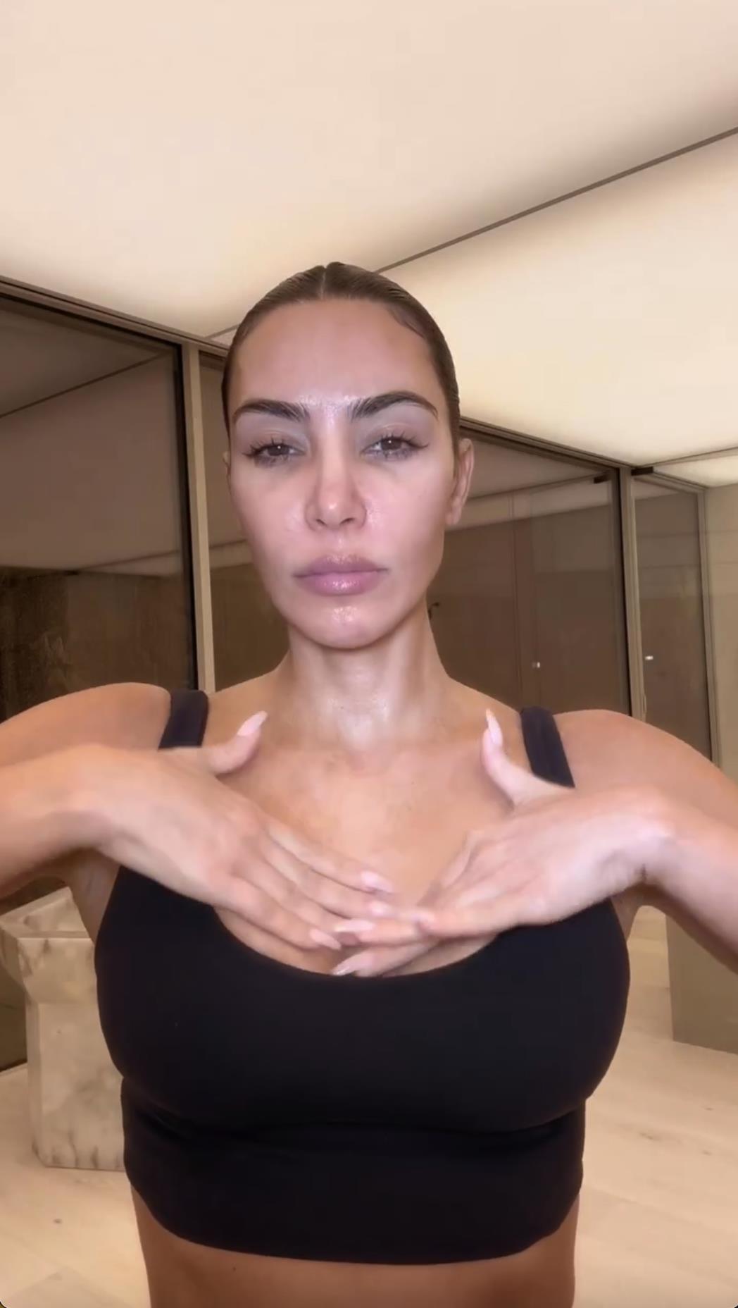Kim Kardashian flaunts her tiny waist as she ditches her top in new video taken inside huge bathroom of her $60M mansion