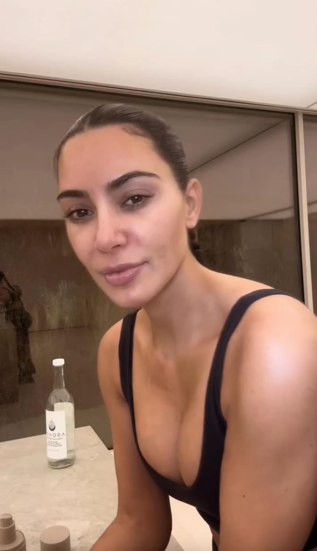 Kim Kardashian flaunts her tiny waist as she ditches her top in new video taken inside huge bathroom of her $60M mansion