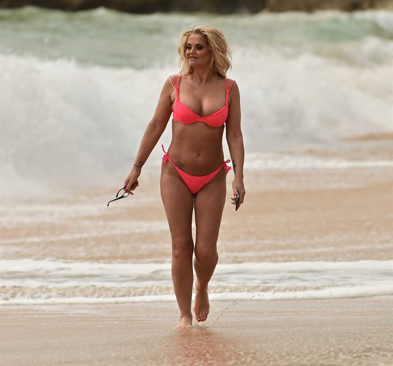 Danniella Westbrook, 49, looks incredible as she strips off to neon pink thong bikini on the beach in Portugal