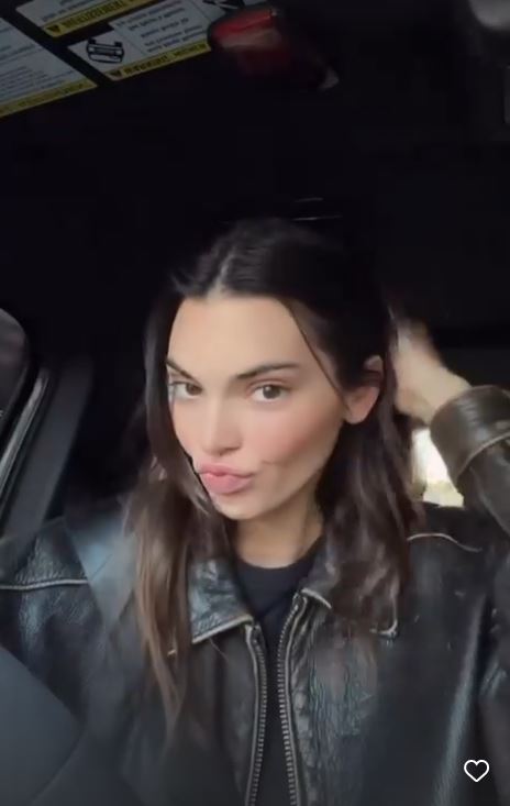 Kendall Jenner goes braless as she flaunts tiny waist in black dress for unedited video after rumors she got a boob job
