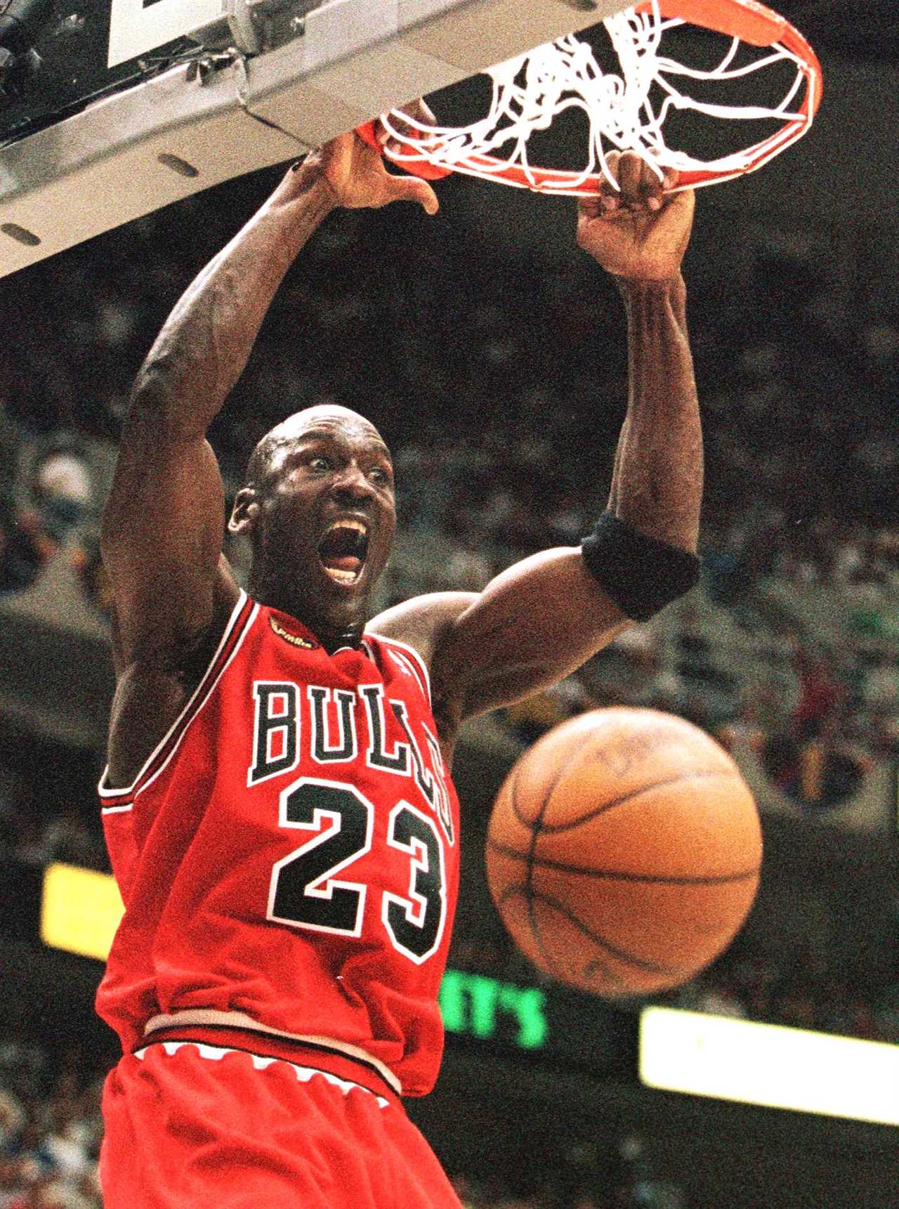 SALT LAKE CITY, UNITED STATES: Michael Jordan of the Chicago Bulls hang son the rim after a dunk 05 June against the Utah Jazz in game two of the NBA Finals at the Delta Center in Salt Lake City, UT. Jordan had a game high 37 points leading the Bulls to a victory 93-88 to tie the series at 1-1. AFP PHOTO/Jeff HAYNES (Photo credit should read JEFF HAYNES/AFP via Getty Images)