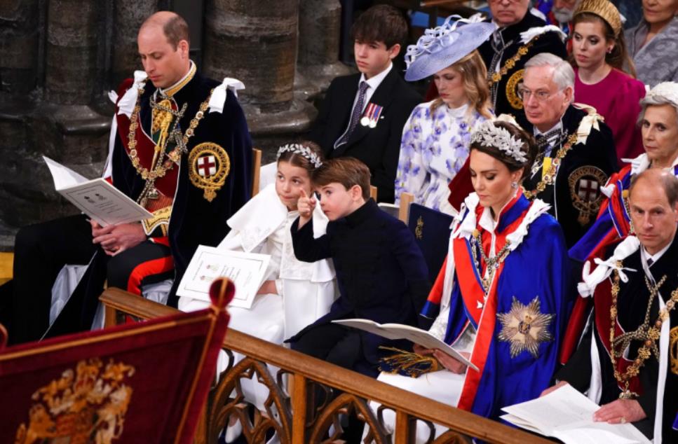 Adorable moment Prince Louis leans over to chat to big brother George as they brave rain on Buckingham Palace balcony