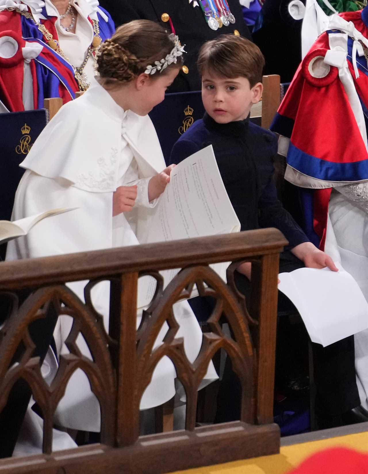 Adorable moment Prince Louis leans over to chat to big brother George as they brave rain on Buckingham Palace balcony