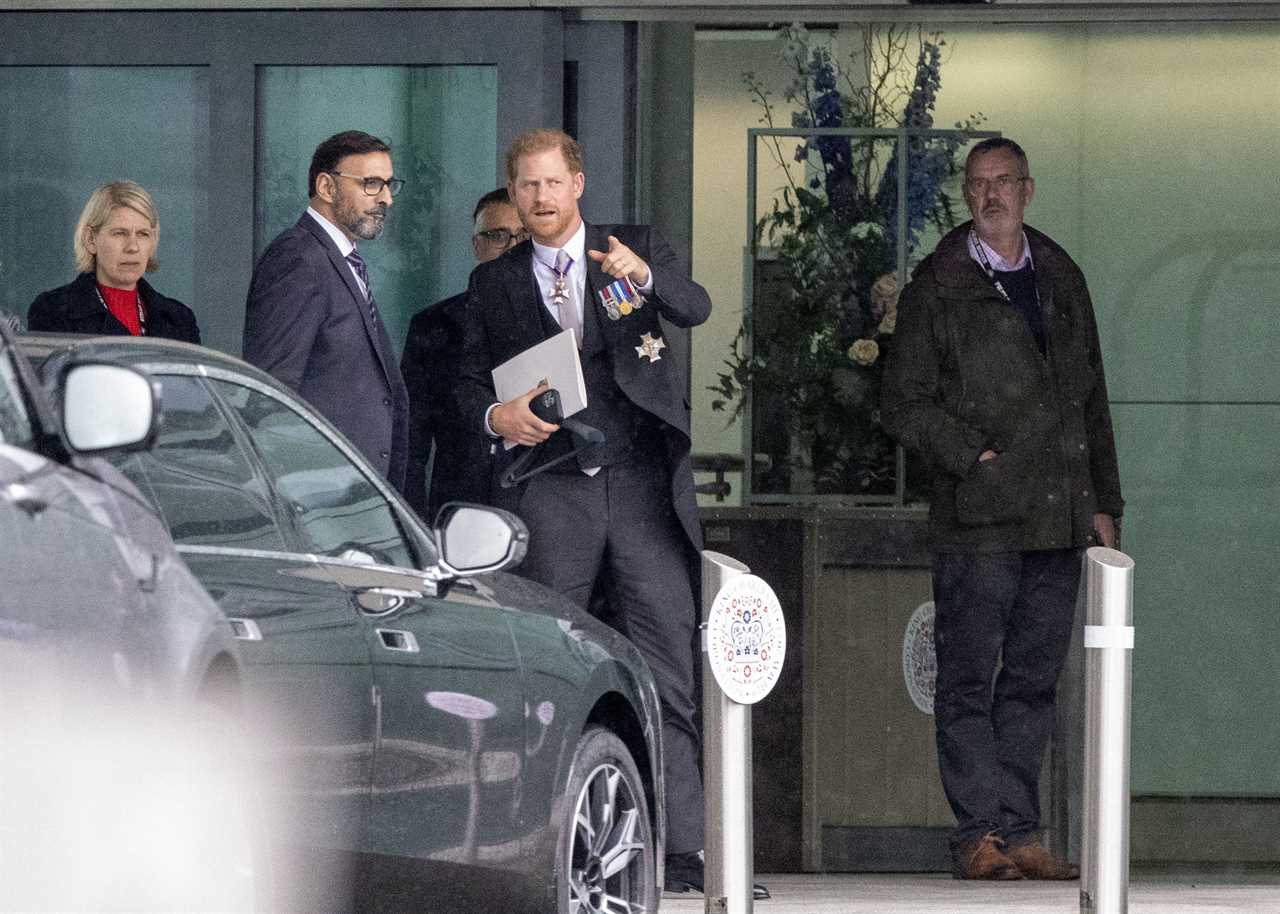 Prince Harry grins at Heathrow before jetting to LA just an hour after coronation as his family wave on Palace balcony