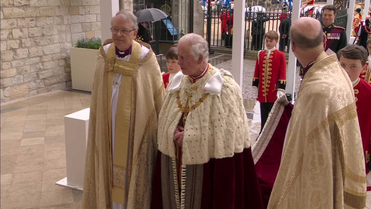 Prince George, 9, looks solemn as he holds his grandfather King Charles’ robe in special role at coronation procession