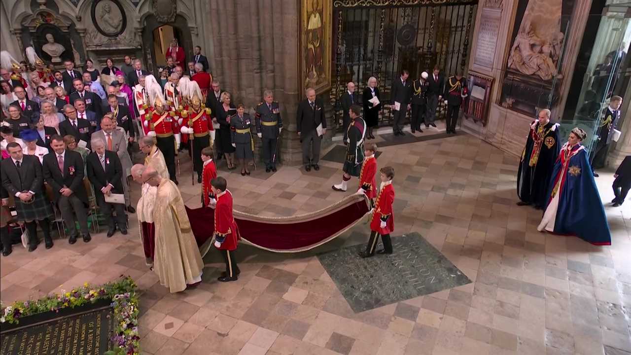 Prince George, 9, looks solemn as he holds his grandfather King Charles’ robe in special role at coronation procession