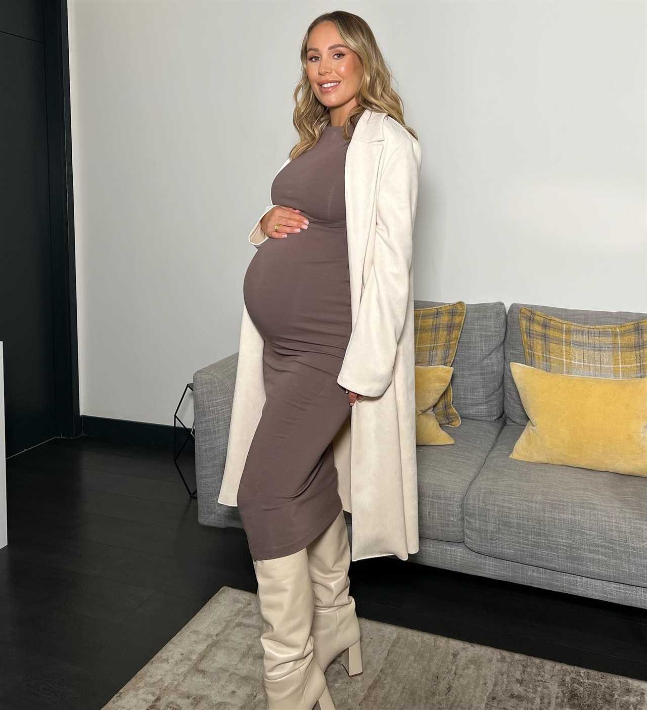 Kate Ferdinand shows off her huge baby bump in skintight dress as she struggles taking her boots off