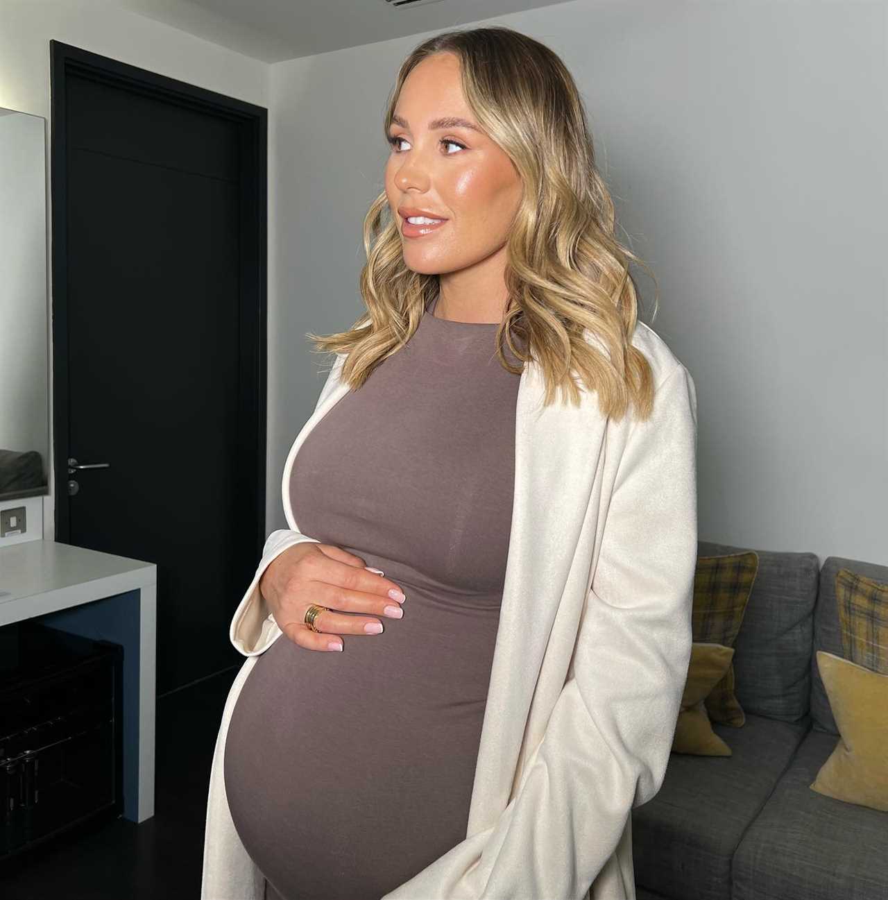 Kate Ferdinand shows off her huge baby bump in skintight dress as she struggles taking her boots off