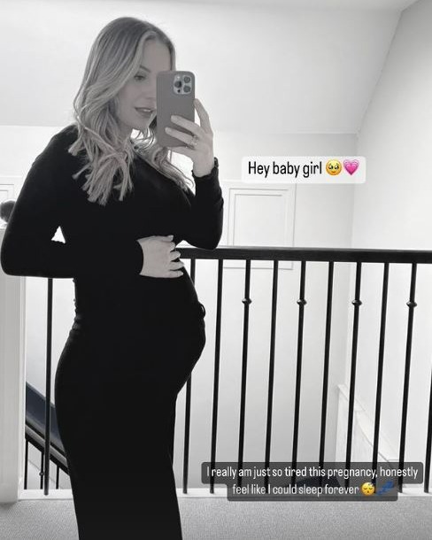 Kate Ferdinand shows off her huge baby bump in skintight dress as she struggles taking her boots off