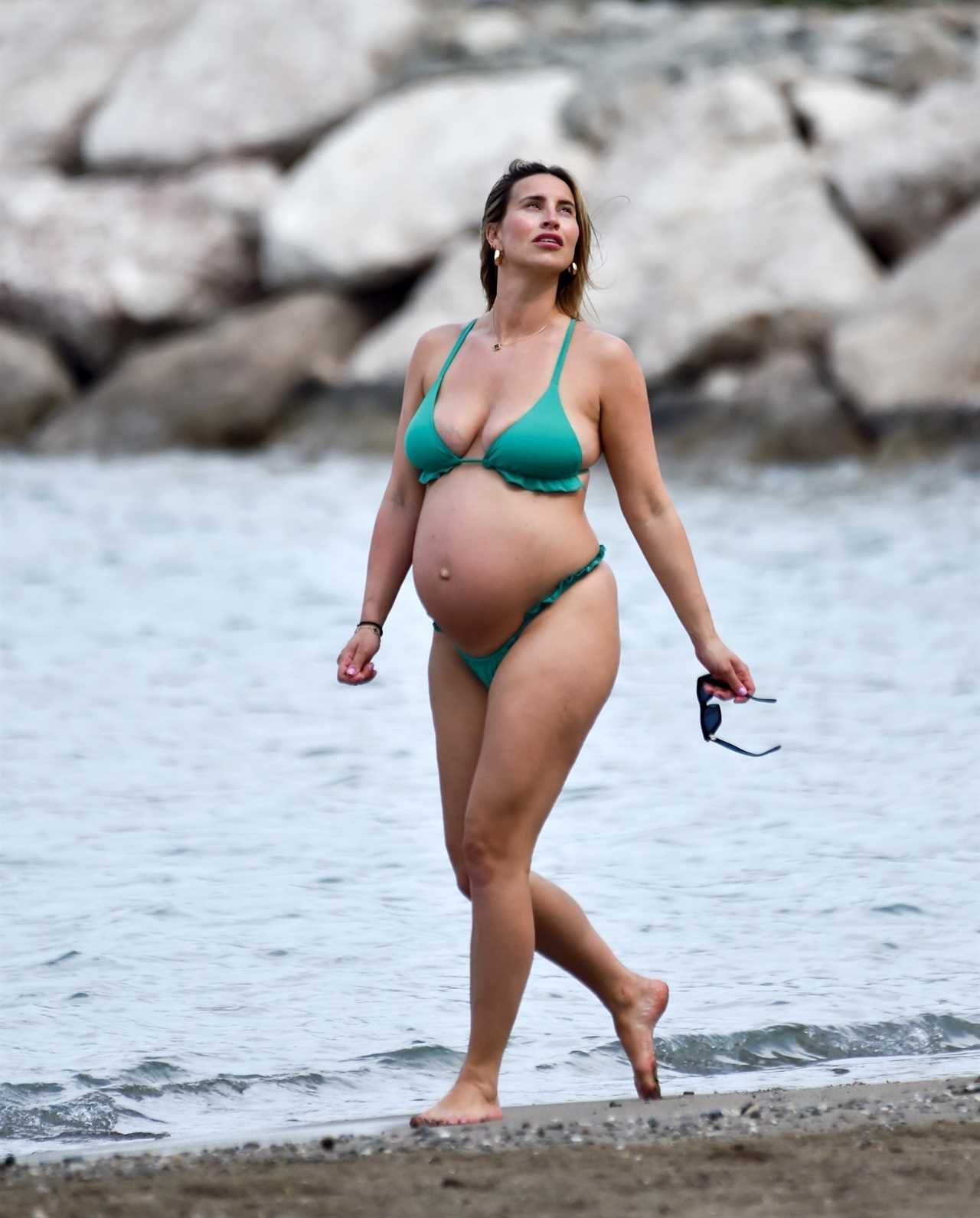 Ferne McCann shows off blossoming baby bump in green bikini on the beach – as she counts down to birth of second child