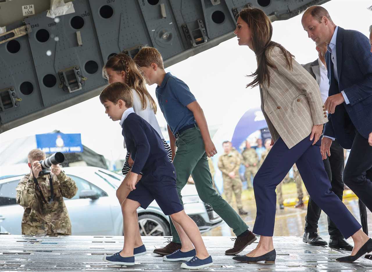 Prince Louis gives a shy wave as Kate helps him climb onto a quad bike during family day out with siblings at air show