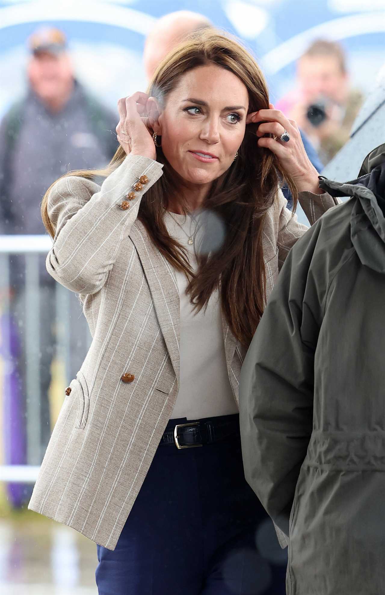 Prince Louis gives a shy wave as Kate helps him climb onto a quad bike during family day out with siblings at air show