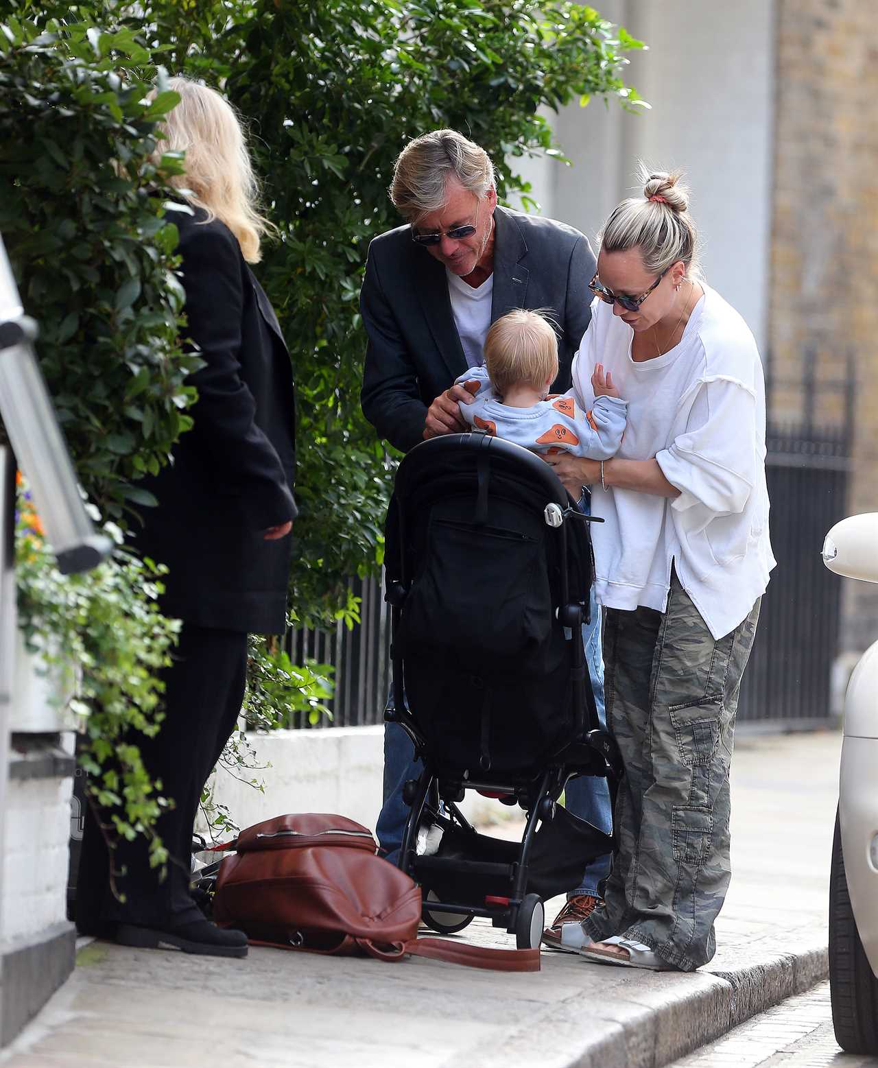 Richard Madeley showcases his doting grandfather side as he cuddles baby Bodhi on a family outing