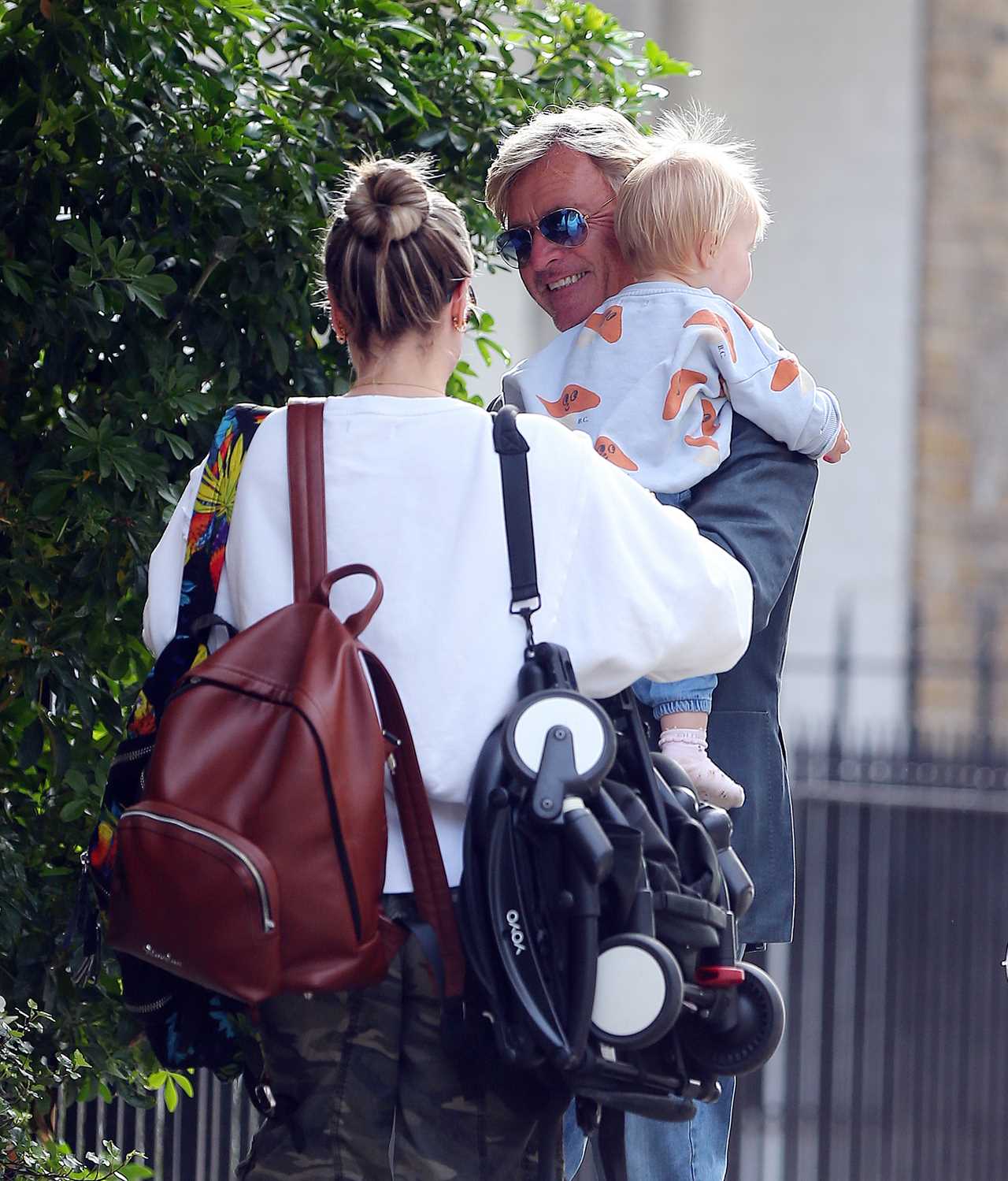 Richard Madeley showcases his doting grandfather side as he cuddles baby Bodhi on a family outing