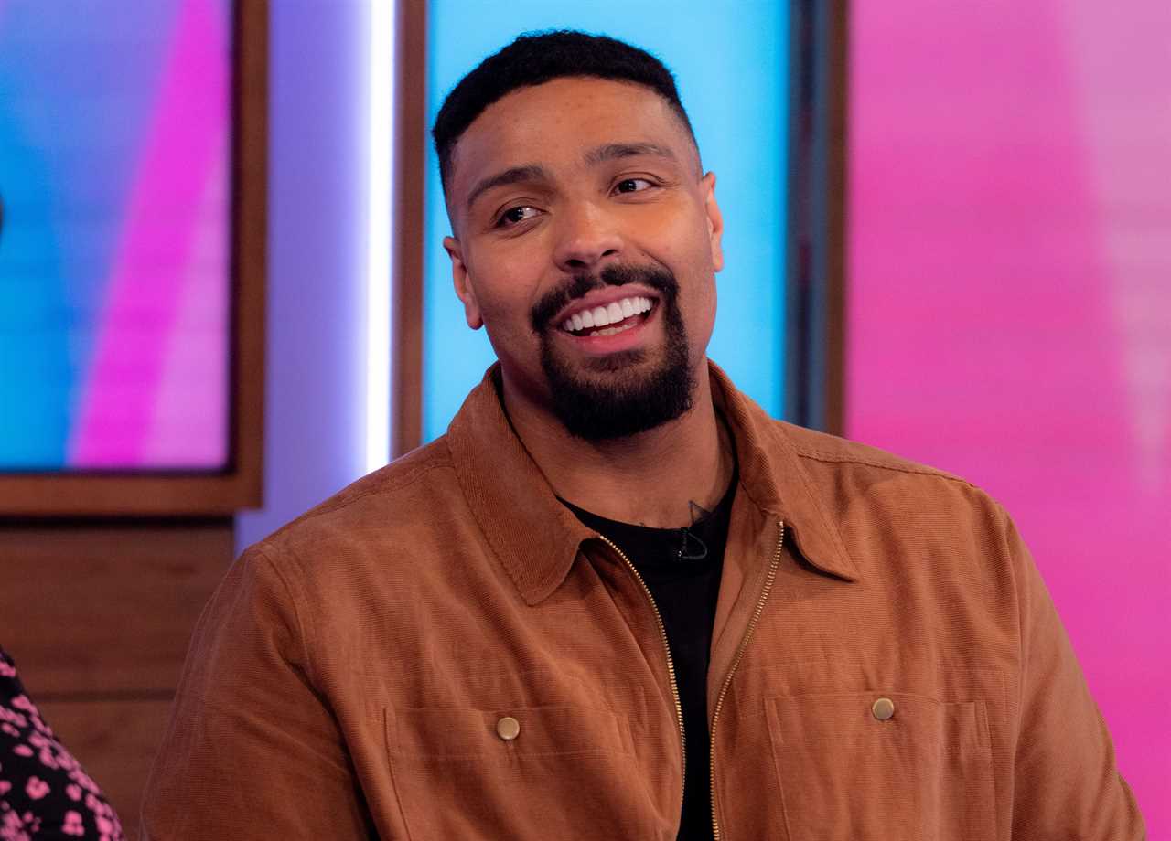 a man with a beard is smiling in front of a pink background