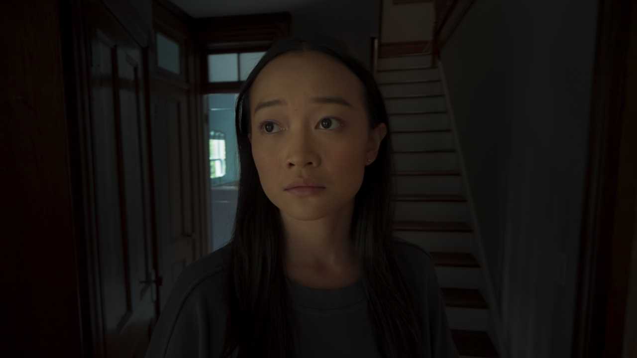 Film still of Callina Liang as Chloe in a dark hallway;