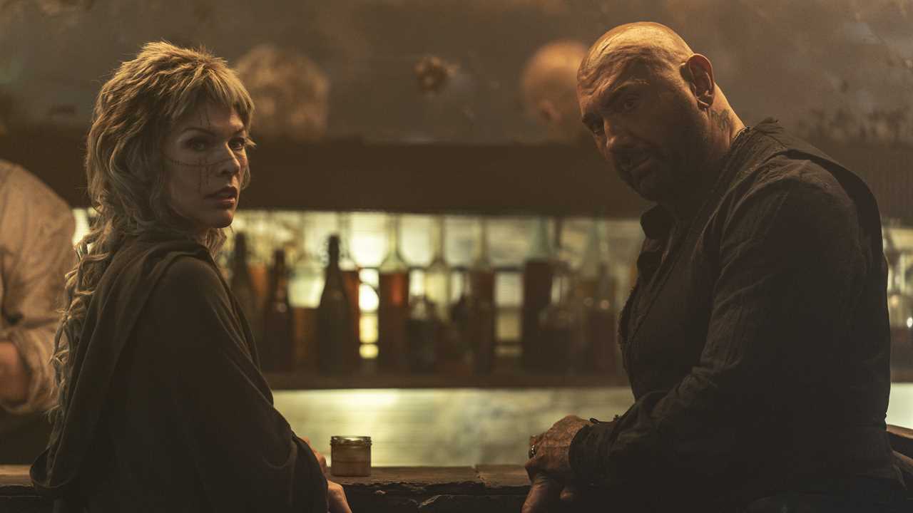 Film still of Milla Jovovich and Dave Bautista in *In the Lost Lands*.